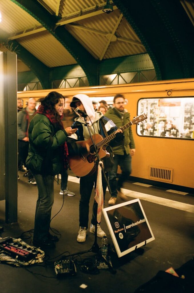 pexels photo 3824763 A guitarist and singer perform in a bustling subway station, creating a lively atmosphere.