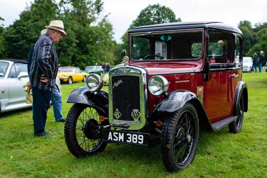 pexels photo 9175386 Classic Austin 7 car showcased at an outdoor car gathering with attendees around.
